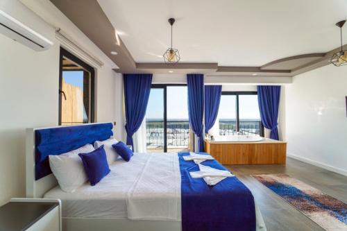 1 dormitorio con 1 cama grande y cortinas azules en Villa Legendary 2 en Kumluova