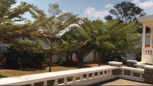 a white bench in front of a building with trees at B&B/chambres d'hôtes in Antananarivo
