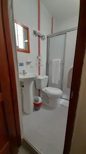 a bathroom with a toilet and a sink at HOTEL SAN ADOLFO in Apartadó
