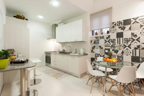a kitchen with a glass table and white cabinets at Ginjinha House - 4 Rooms - Bairro Alto - with AC by Lisbeyond in Lisbon