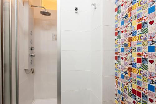 a shower with a glass door next to a shower at Ginjinha House - 4 Rooms - Bairro Alto - with AC by Lisbeyond in Lisbon
