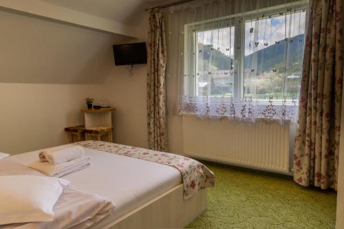 una piccola camera da letto con un letto e una finestra di Vila Rustica a Moieciu de Sus