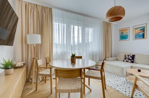 a living room with a table and chairs and a couch at Złoty Apartament in Krynica Zdrój