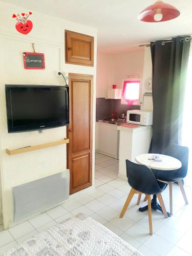 une petite cuisine avec une petite table et une télévision dans l'établissement coquet Studio Classé Deux Étoiles, Balcon avec Table, et Wifi, à Gréoux-les-Bains