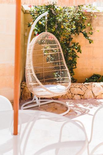 a rattan chair sitting on a table at Ogygia Suites Gozo in Għarb