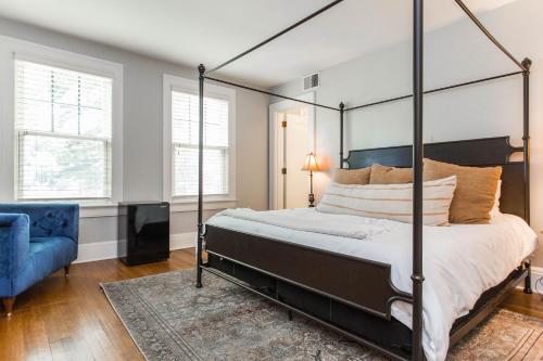 a bedroom with a canopy bed and a blue chair at William Rockhill Nelson at Southmoreland on the Plaza in Kansas City
