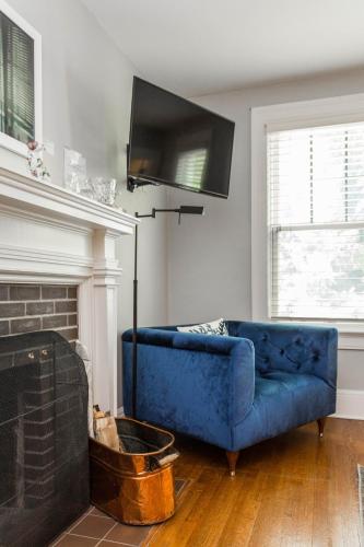 a blue couch in a living room with a fireplace at William Rockhill Nelson at Southmoreland on the Plaza in Kansas City