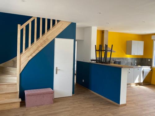 une cuisine avec des murs bleus et jaunes et un escalier dans l'établissement La Margotine, à Saint-Quentin-Lamotte-Croix-au-Bailly
