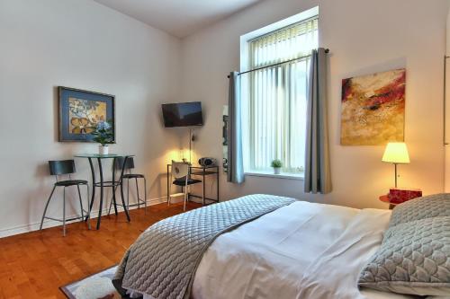 1 dormitorio con cama, ventana y TV en Apartment et Studio montreal, en Montreal