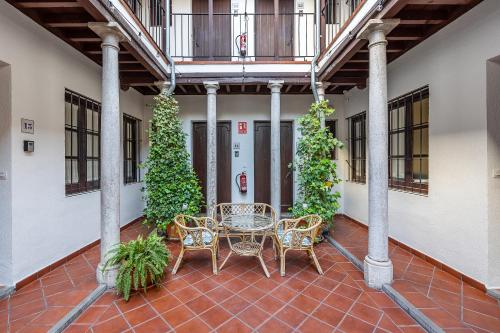 a patio with a table and chairs and plants at ADANAR-Las Columnas in Granada