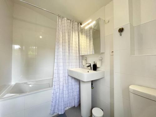 y baño blanco con lavabo y bañera. en Maison idéale pour visiter Paris Versailles - Chambres privées Paris-Saclay, en Bures-sur-Yvette