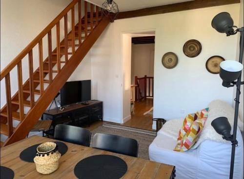 ein Wohnzimmer mit einem weißen Sofa und einem Tisch in der Unterkunft Le gite la petite Fronsadaise in Guîtres