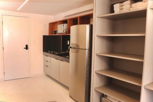 a kitchen with a refrigerator and some shelves at Unity #423 - Elegância à beira-mar por Carpediem in Penha