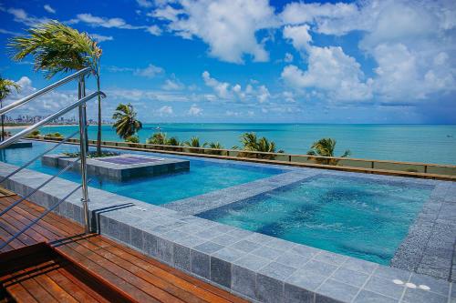 a swimming pool with a view of the ocean at Unity #423 - Elegância à beira-mar por Carpediem in Penha