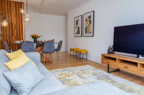 sala de estar con sofá azul y TV de pantalla plana en JB Comfort Flat en Ponta Delgada