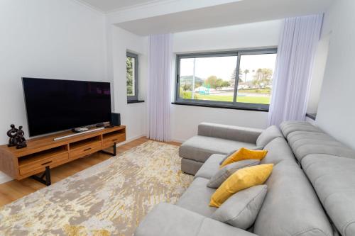 sala de estar con sofá y TV de pantalla plana en JB Comfort Flat en Ponta Delgada