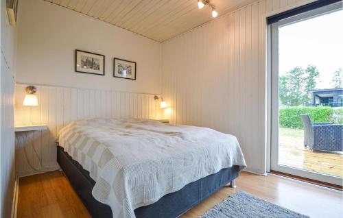 een slaapkamer met een bed en een groot raam bij Awesome Home In Hornslet With 2 Bedrooms And Wifi in Hornslet