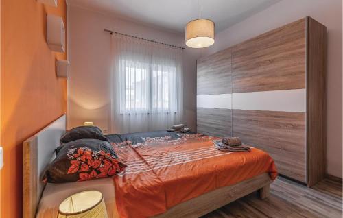a bedroom with a large bed with an orange comforter at 3 Bedroom Awesome Home In Marcana in Marčana