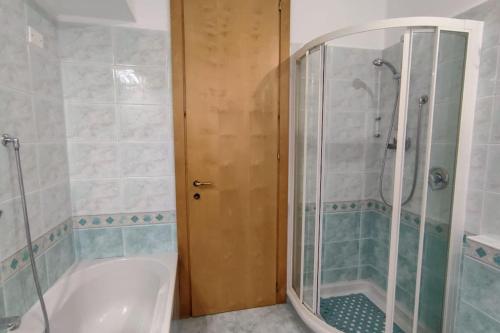 a bathroom with a tub and a shower with a glass door at Elegante alloggio zona storica in Lecco