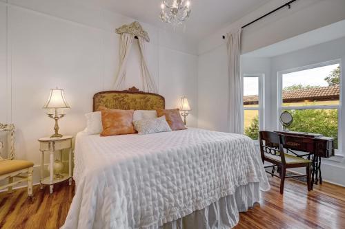 a bedroom with a bed and a desk and a window at The Gatsby Mansion Heated Pool Heart of Town in St. Augustine