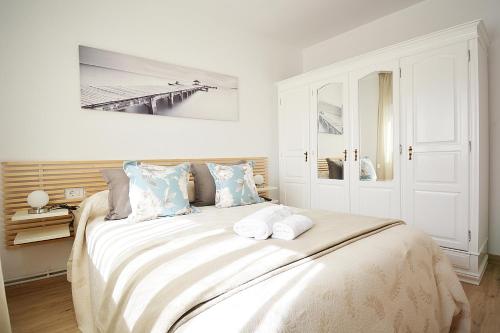 a white bedroom with a large bed with pillows at A Casa do Olivo in Meis
