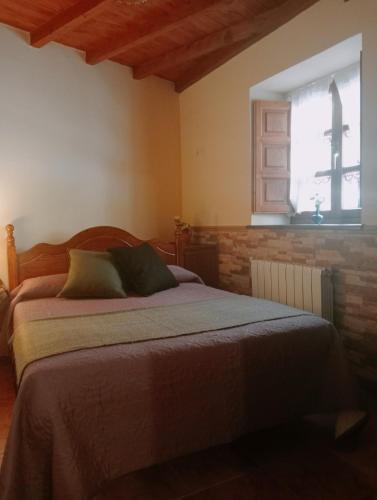 Schlafzimmer mit einem Bett und einem Fenster in der Unterkunft Casa Villastur in Covadonga