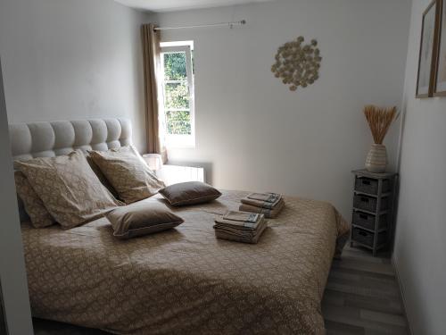 een slaapkamer met een bed met twee boeken erop bij Le Petit Gite de la Roseraie in Quiberville