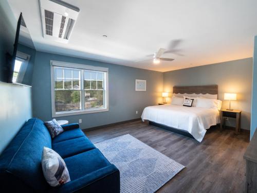 Long Beach Suites في غلوستر: غرفة معيشة مع سرير وأريكة زرقاء