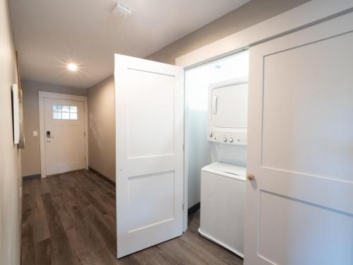 a kitchen with a washer and dryer next to a door at Long Beach Suites in Gloucester
