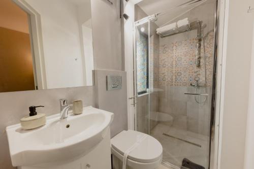 a white bathroom with a sink and a shower at No. 55 in Buzau
