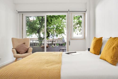 a bedroom with a large white bed with yellow pillows at Sunny Suites Lisbon in Lisbon