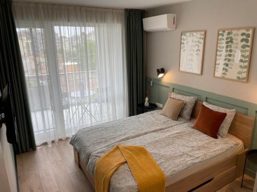 a bedroom with a bed and a large window at Dream_Apartment in Varna City
