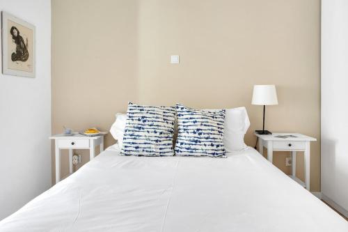 a bedroom with a white bed with two night stands at Apartment in Estrela - Amazing for Families by Lisbeyond in Lisbon