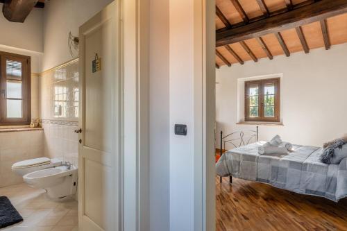 1 dormitorio con 1 cama y baño con aseo en Casa Vecchia Rooms and Parking, en Gambassi Terme