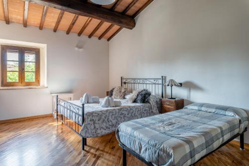 1 dormitorio con 2 camas y ventana en Casa Vecchia Rooms and Parking, en Gambassi Terme