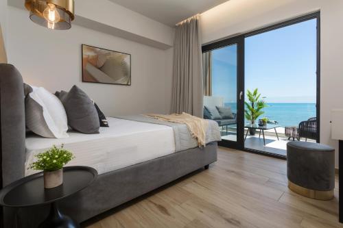 a bedroom with a bed and a view of the ocean at Akrogiali Luxury View in Laganas