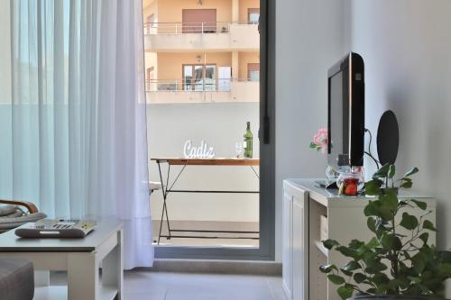 ein Wohnzimmer mit einem TV und einem Balkon in der Unterkunft Apartamento San Leonardo Playa (Free Parking) in Cádiz