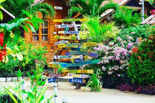 a pile of signs in a garden with flowers at Mithra Paradise Beach Hotel in Nilaveli