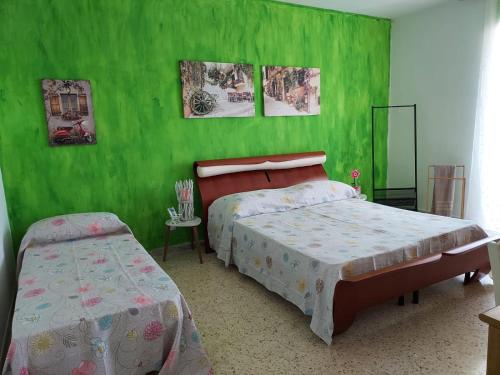 a bedroom with two beds and green walls at L'Ancora in Bisceglie