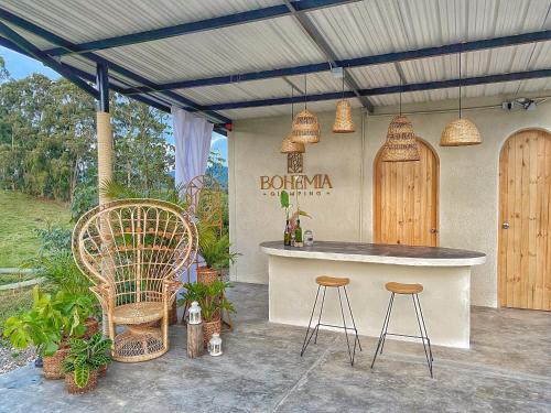 a outdoor kitchen with two stools and a counter at Bohemia Glamping 