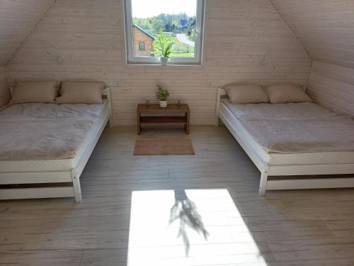2 camas en una habitación con 2 ventanas en Domki Platinium Chłopy - Sarbinowo, en Chłopy