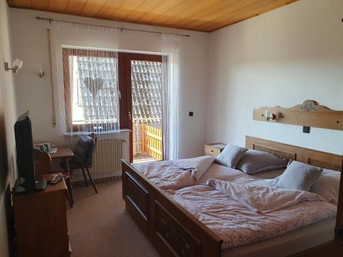 - une chambre avec un grand lit et une télévision dans l'établissement Haus Drei Seen, à Walkenried