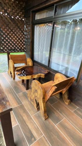 a log cabin with a table and a bench at La Fortuna Waterfall Bungalows in Fortuna