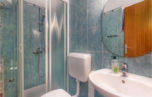 a bathroom with a toilet and a sink and a mirror at 4 Bedroom Pet Friendly Home In Soline in Soline