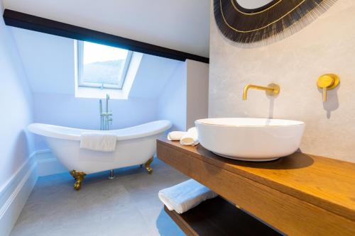een badkamer met een groot wit bad en een wastafel bij Casa do Estanco in Quiroga