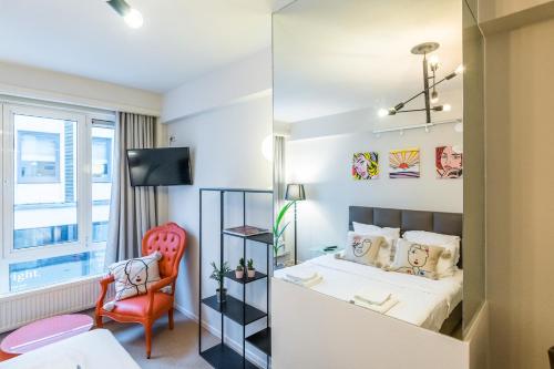 a small bedroom with a bed and a chair at Japie rooms - in the heart of Antwerp in Antwerp