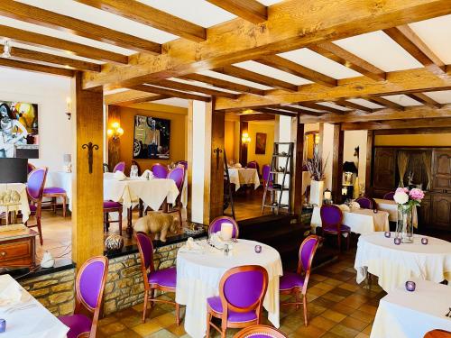 un restaurant avec des tables blanches et des chaises violettes dans l'établissement Hostellerie Sainte-Cécile, à Florenville