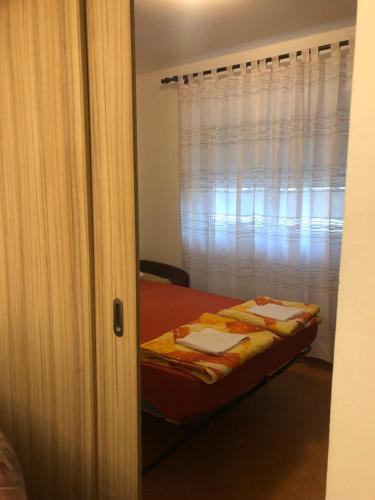 a bedroom with a bed and a window with curtains at Apartmani Vedrana in Sutomore