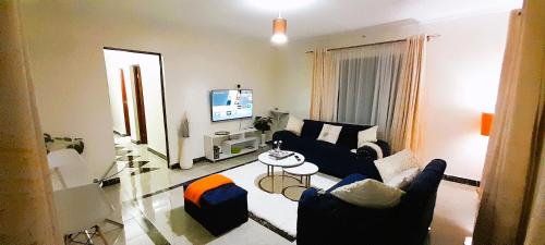a living room with two couches and a tv at Sparkle Homes 