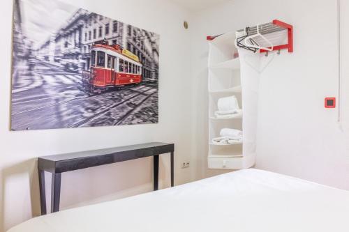 a bedroom with a bed and a picture of a tram at Studio in the heart of Alfama! Super Central! in Lisbon